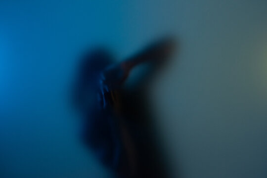 Black American man dancing behind frost glass