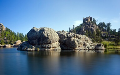 Obraz premium Sylvan Lake South Dakota granite formations and calm water on a clear day