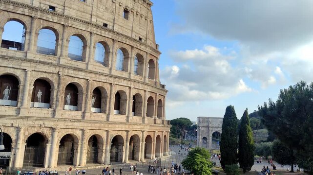 Low angle pan of the iconic curved stone arches of the Colosseum.
