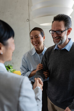 Real estate agent meeting with a multicultural couple during a property consultation. Professional discussion about buying, renting, or investing in a new home