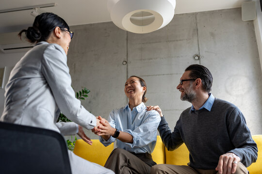 Real estate agent meeting with a multicultural couple during a property consultation. Professional discussion about buying, renting, or investing in a new home.
