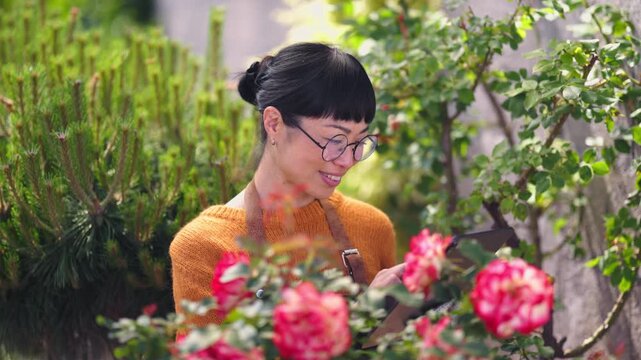 Woman checks plant care tips in garden