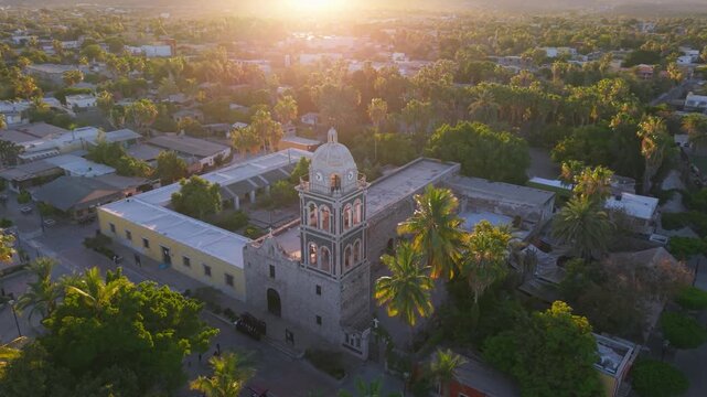 Witness the sunset over Loreto Mission church in Baja California Sur Mexico showcasing the beauty of the desert and marina area.