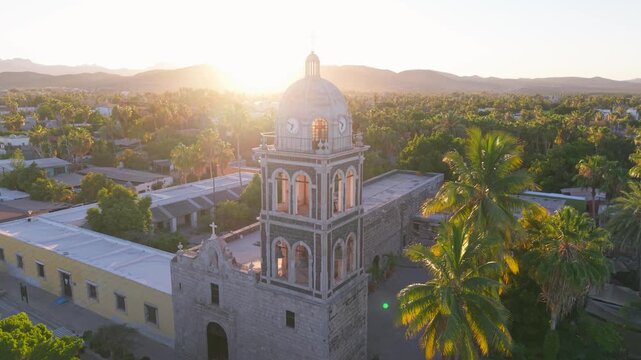 Aerial views showcase the Loreto Mission church at sunset with stunning colors over the desert oasis in Baja California Sur, Mexico.