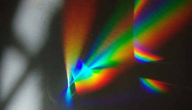 A vibrant rainbow of colors shines brightly in a dark room with a window