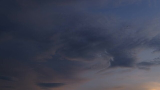 Serene sunset timelapse with static clouds fading into twilight. Minimalist dark evening sky gradient with smooth color transition. 4K.