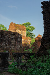 Obraz premium Ancient temple walls and stone relics inside My Son Sanctuary archaeological complex in Quang Nam, Vietnam.