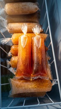 Indonesian Sweet Tea Ice Pops in Freezer Basket, 
Traditional Es Mambo Street Food, 
Homemade Frozen Dessert