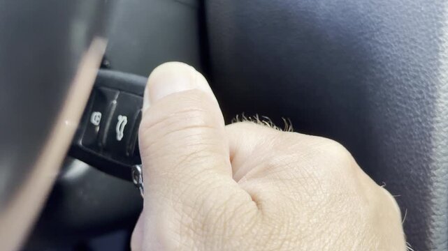 A hand turns the key in a car ignition switch inside the cabin. This movement triggers a sharp mechanical click and a low engine starter sound.