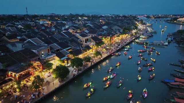 Illuminated riverside streets and lantern boats create a vibrant evening atmosphere in Hoi An.