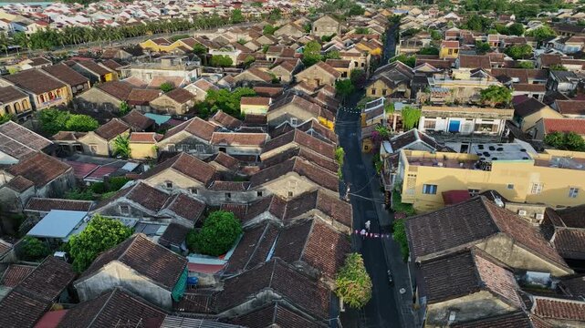 Drone perspective looking down a narrow heritage street lined with traditional houses in Hoi An.