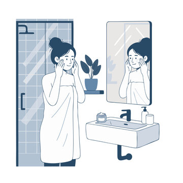 Woman in towel applying face cream in bathroom mirror skincare routine