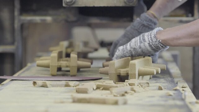 Worker Trimming Industrial Parts on Assembly Line