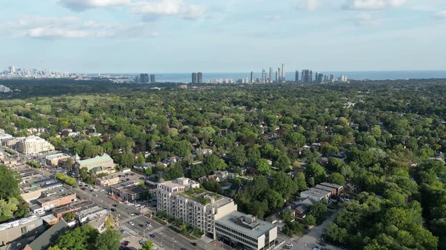 Aerial over Bloor Street West in Kingsway, Toronto, Ontario, Canada. Downtown core Toronto skyline, Mimico and Lake Ontario in the distance, turning left towards the east.