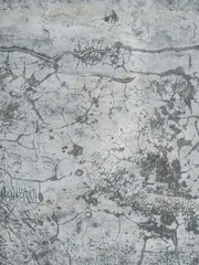 Fototapeta premium Grey concrete wall with deep branching cracks and weathered texture