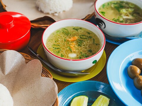 Traditional Indonesian chicken soto soup served on table.