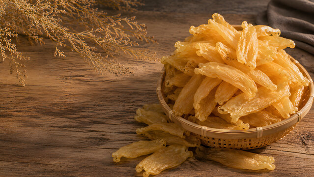 Premium Dried Fish Maw in Bamboo Basket on Wooden Table with Warm Golden Light