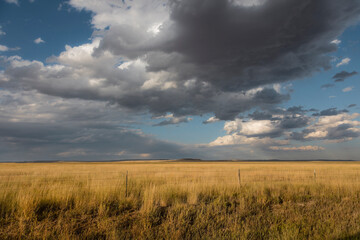Storm clouds over open rangeland and rural property line © jia