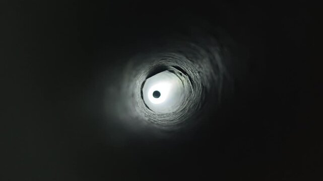 Flashlight checking or inspecting inside aluminum dryer vent pipe ventilation hole smooth surface after deep cleaning. Clean round duct empty space with good airflow and condition.
