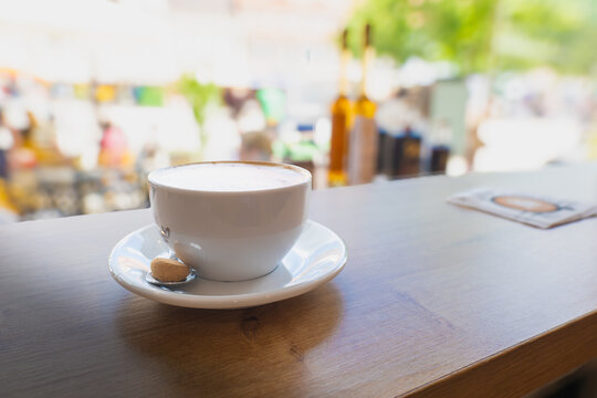 Frischer Cappuccino mit Amarettini in einem Caf&eacute; an einem belebten Marktplatz