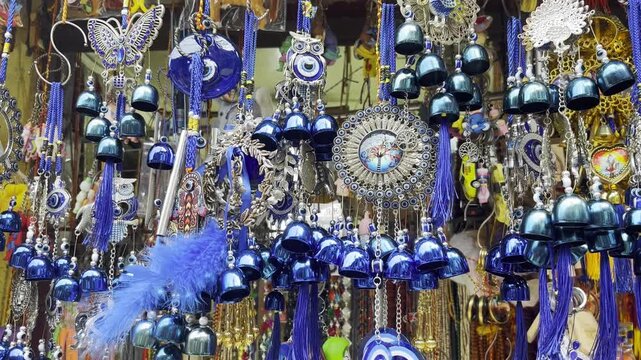 Shot of Traditional Turkish Souvenirs, Nazar Amulet, Blue Evil Eye, Indiann door and wall hanging  decorations, nazar chrms hanging in a market stall