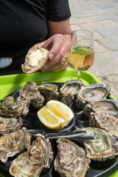 Pairing fresh oysters with Loire Muscadet white crisp, mineral wine; seaside tradition of family growers, simple and communal seaside dining in Saint-Malo, Brittany, Cancale oysters, France