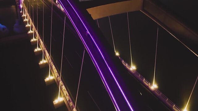 Colorful illuminated arch bridge over river at night