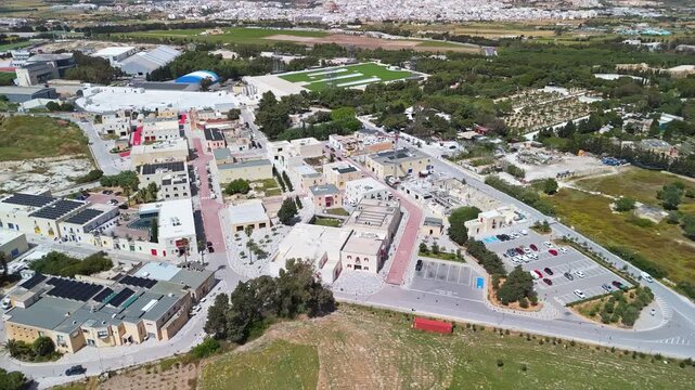 In Ta' Qali, Malta, an aerial view captures the National Park and nearby Artisan Village buildings set among greenery, open fields, and walking paths within this public outdoor area.