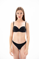 Obraz premium Beautiful girl in black lingerie posing on a white Isolated background