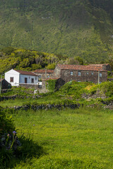 Aldea rural tradicional con casas de piedra y una iglesia blanca bajo colinas. © Maxi Perez