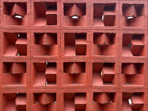 Red painted concrete roster ventilation block wall pattern background.
