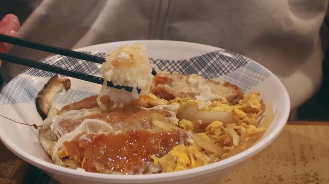 Close-up of a bowl of Waat dan fan or Slippery egg rice being eaten, local breakfast dish served in classic Cha chaan teng diner in Hong Kong