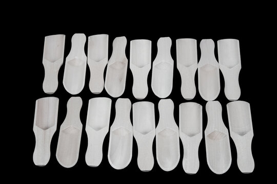 A photographic study of wooden spice spoons and wooden bowls used for snacks and chips, made from various types of wood and used in kitchens. Various wooden spice spoons and wooden bowls.