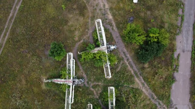 Top down aerial scene with vintage Antonov An-2 biplanes and Aero L-29 trainer jets on overgrown abandoned field
