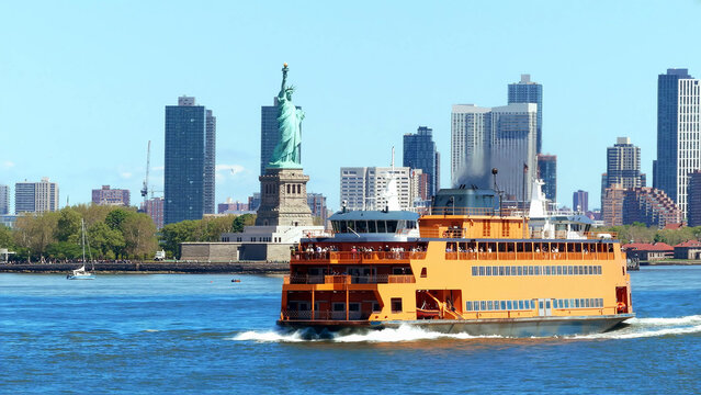 A Staten Island Ferry vessel crosses New York Harbor with the Statue of Liberty and Lower Manhattan skyline in the background.
