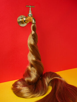 We see hair coming out of a tap on a red wall instead of water, 