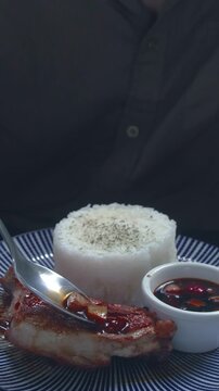Close-up adding fresh tomato with soysauce and vinegar condiment over pritong manok or fried chicken showing authentic local Filipino food from the Philippines