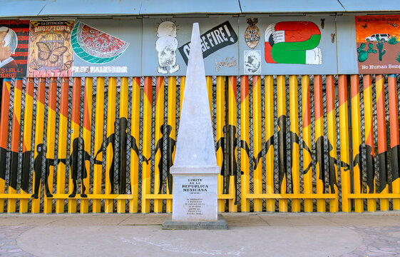 October 5, 2025. Tijuana, Mexico: Historic White Marble International Boundary Marker and Painted Steel Border Wall in Tijuana Mexico