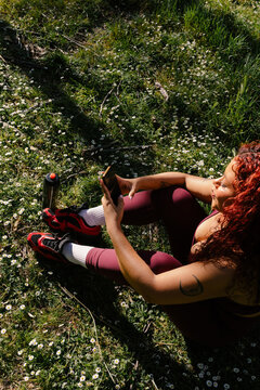 Curvy woman in athletic wear checking her smartphone