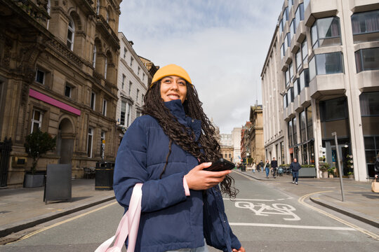 Woman Holding Phone Crossing Liverpool Street