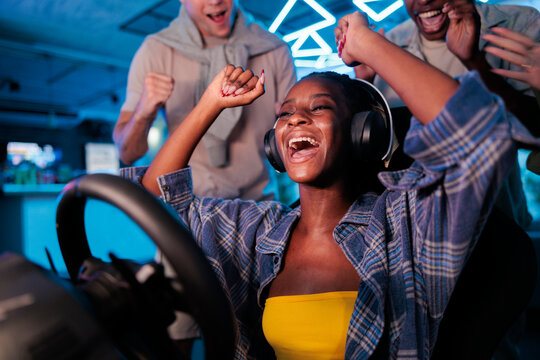 Woman wins racing game, friends celebrate.