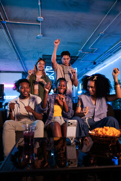 Friends dancing for social media video in neon-lit room