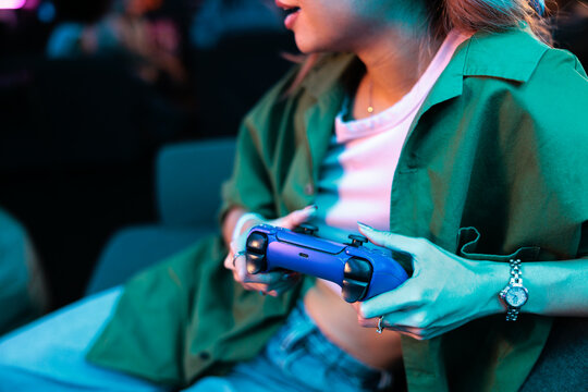 Woman holding game controller while playing video game

