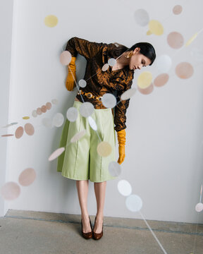 Avant-garde fashion pose with floating paper garlands