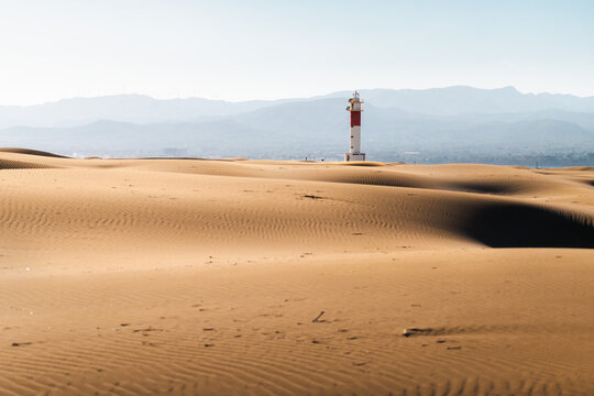 Ebro Delta lighthouse across coastal sand dunes in Deltebre, Catalonia, Spain