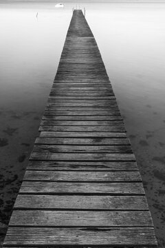 Old wooden jetty for small boats at lakes edge
