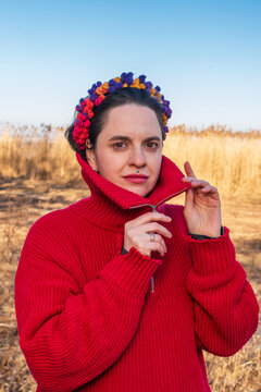 Woman in red sweater adjusting collar with colorful headband