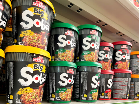Big Soba cup noodles stacked on a shelf in a supermarket