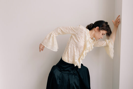 Artistic fashion pose in lace blouse and dark couture skirt