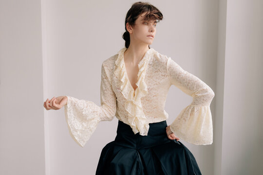 Elegant editorial portrait with lace blouse and dramatic sleeves